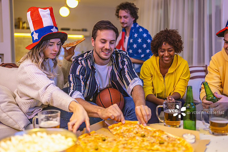 朋友们在看篮球比赛时吃披萨图片素材