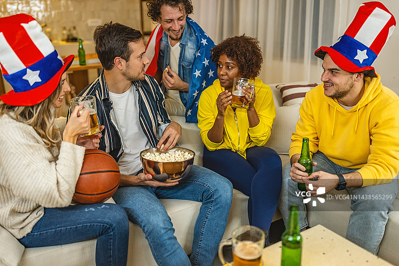 朋友们在家看篮球比赛，玩得很开心图片素材