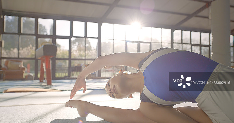 健身房里的体操运动员进行伸展训练，展现健康活力图片素材