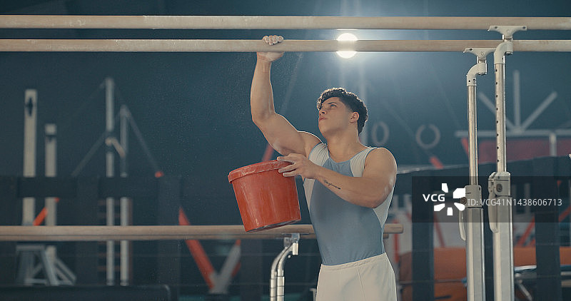 体操、粉末和健身，男体操运动员准备在健身房的单杠上锻炼。锻炼、训练和粉笔，男运动员为他的奥运会表演做准备图片素材