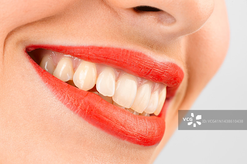 面带微笑，露出牙齿，涂着红色口红图片素材