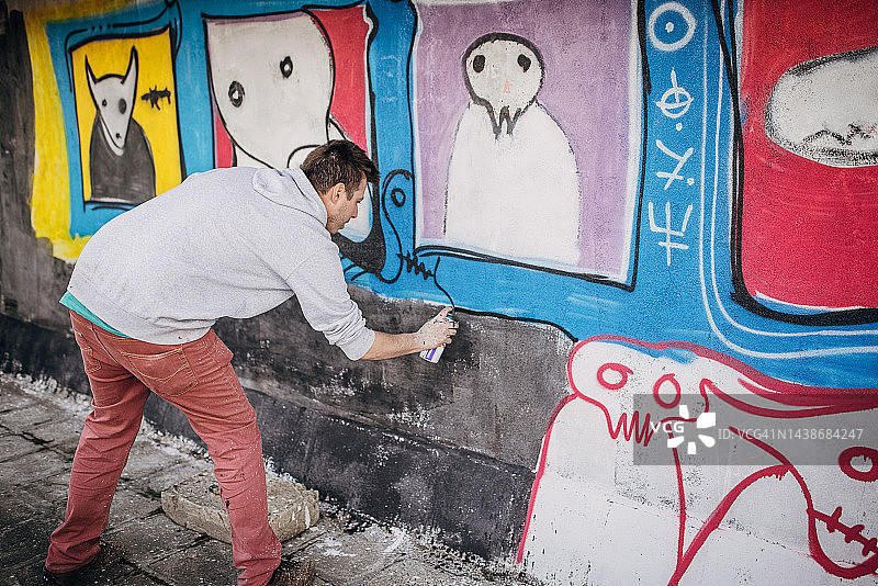 男人在墙上绘制涂鸦图片素材