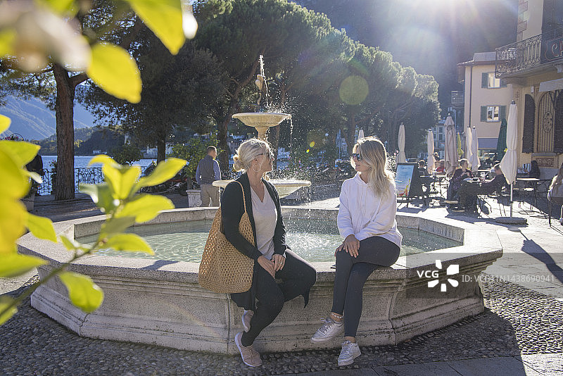 母女在广场喷泉旁放松图片素材