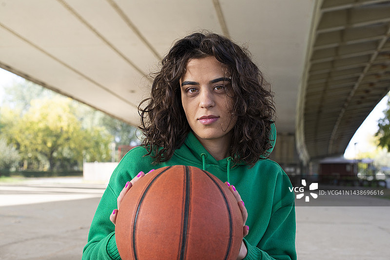 卷发女孩打篮球的肖像图片素材
