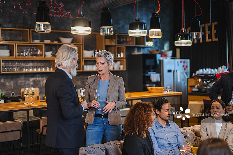 中年男女经理在商务社交活动中交谈并喝香槟图片素材