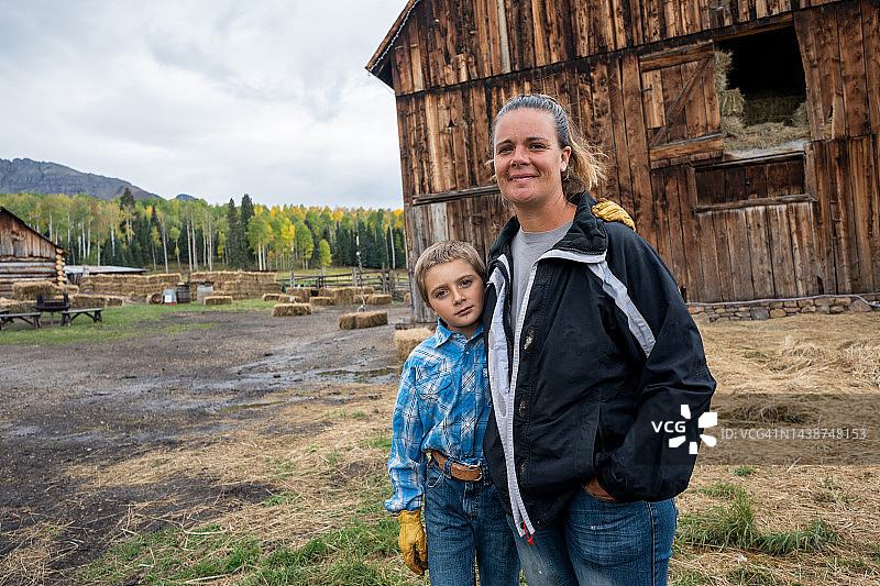 秋季科罗拉多州西南部，年轻母亲和儿子在谷仓和家园前合影图片素材