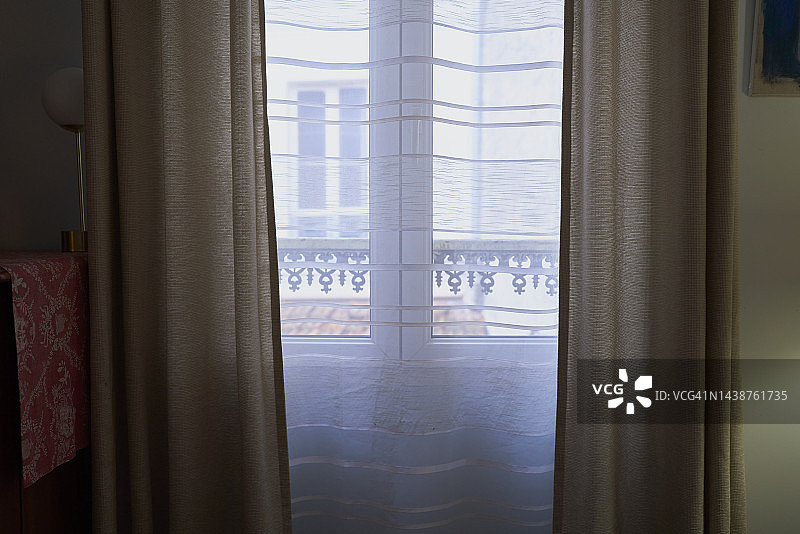 阳光穿过米色窗帘的阳台窗户图片素材