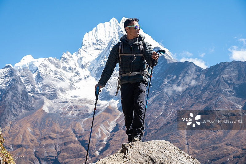 在珠穆朗玛峰大本营徒步旅行的亚洲游客，背景是Thamserku山 (6,608米)图片素材