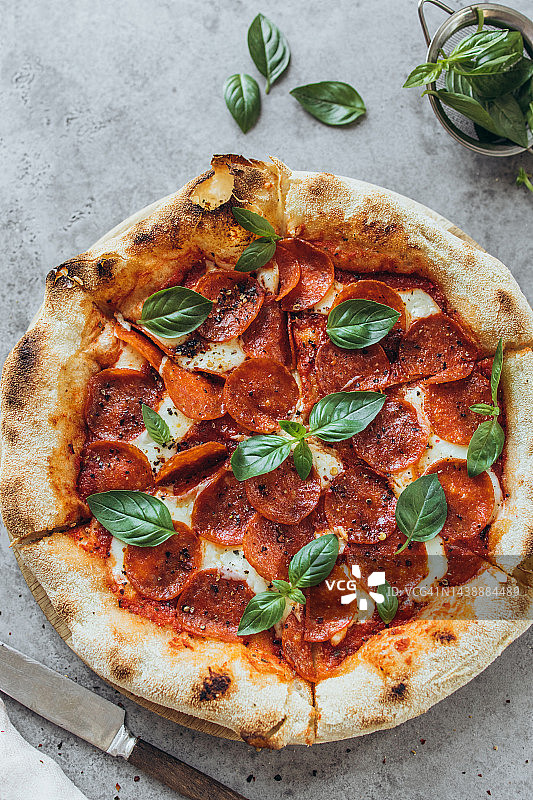 罗勒叶装饰的意大利辣香肠披萨图片素材