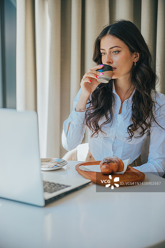 坐在咖啡馆里通过笔记本电脑进行视频会议的美丽女人图片素材