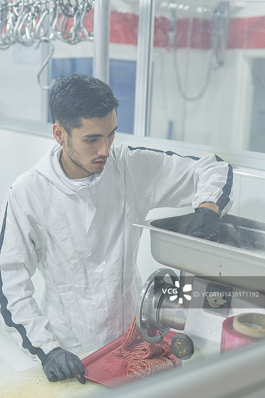 肉店里的屠夫用电动机器绞肉图片素材