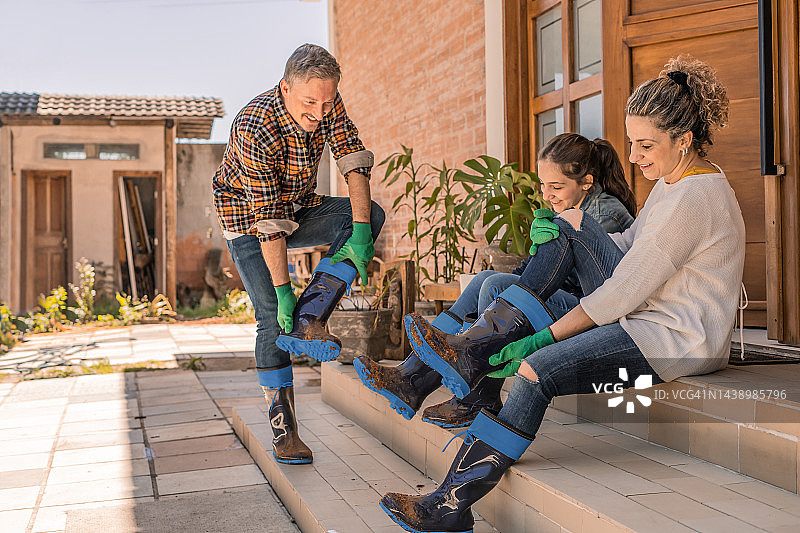 家人脱掉泥泞的靴子图片素材