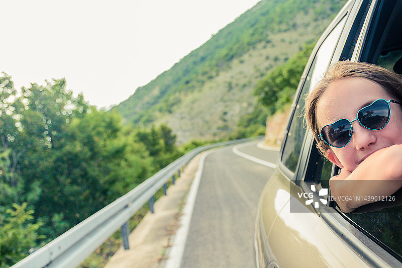 暑假旅行中快乐的女孩探头看向窗外图片素材
