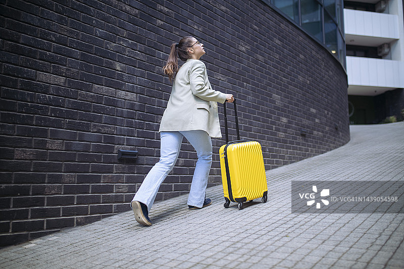 女人拉着黄色行李箱奔跑图片素材