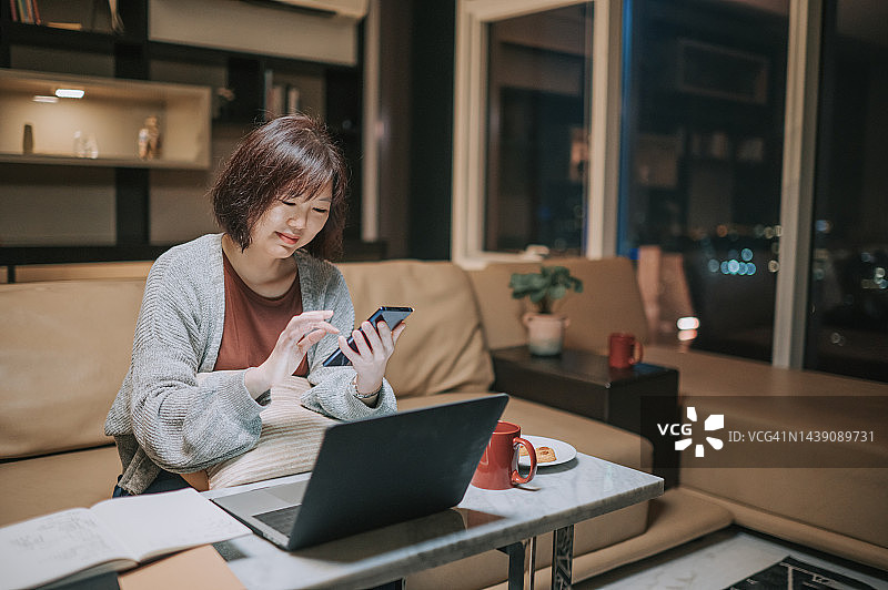 中国女性在家中客厅进行家庭财务规划图片素材