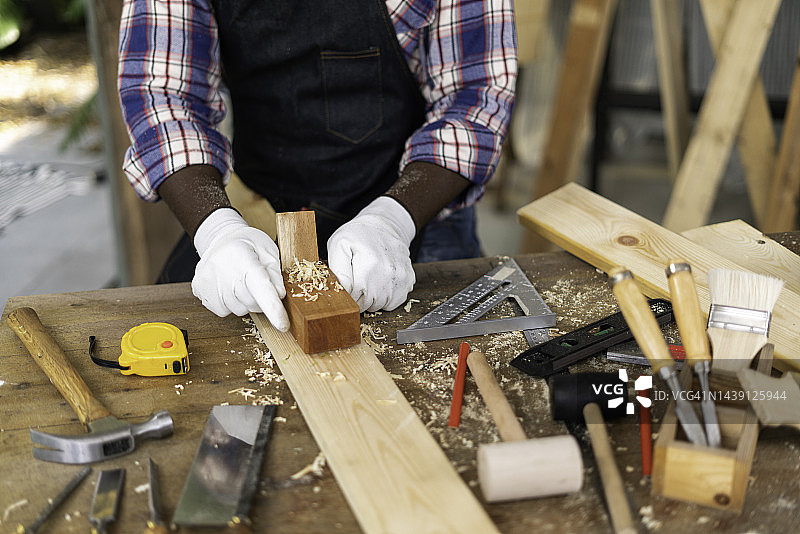 木匠在工作室用刮刀刨木图片素材