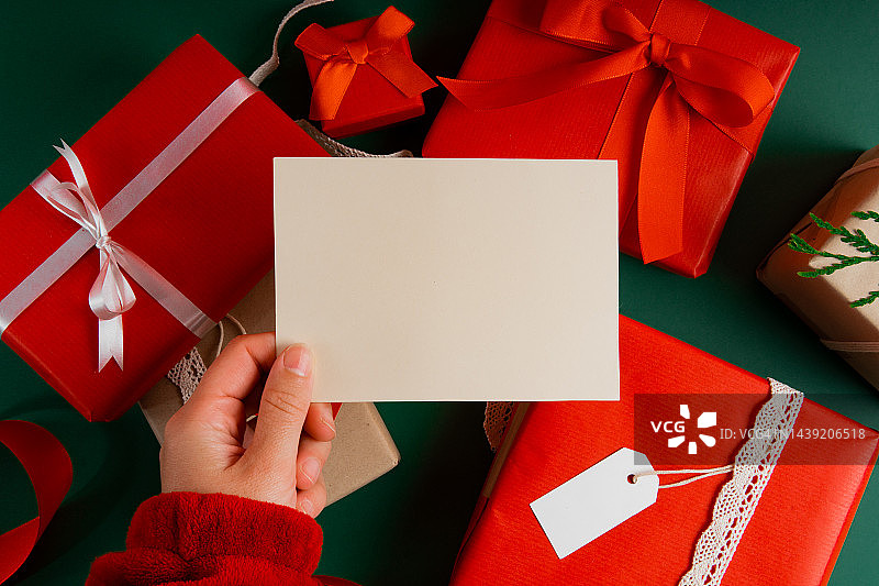 俯视女人手拿明信片样机和礼物图片素材