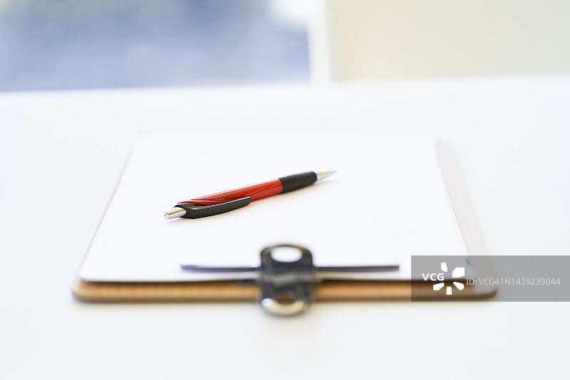 办公桌上的空白剪贴板和笔图片素材