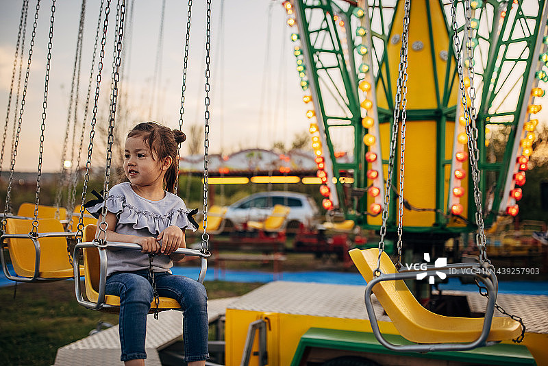 可爱的女孩在旋转秋千上玩耍图片素材
