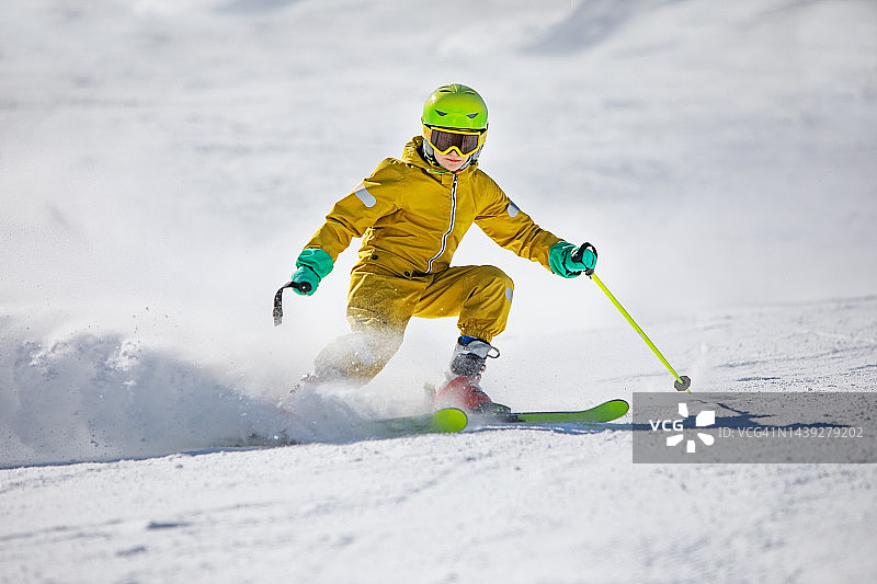男孩在滑雪胜地的山上滑雪图片素材