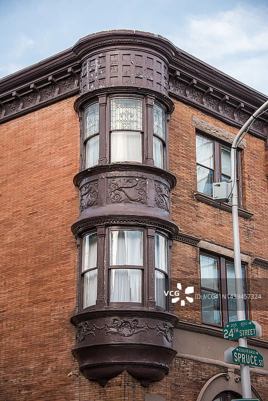 红色砖砌建筑上华丽的维多利亚式转角凸窗图片素材