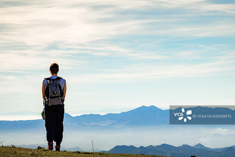 短发女孩背着背包欣赏风景，享受大自然的宁静，风景壁纸图片素材