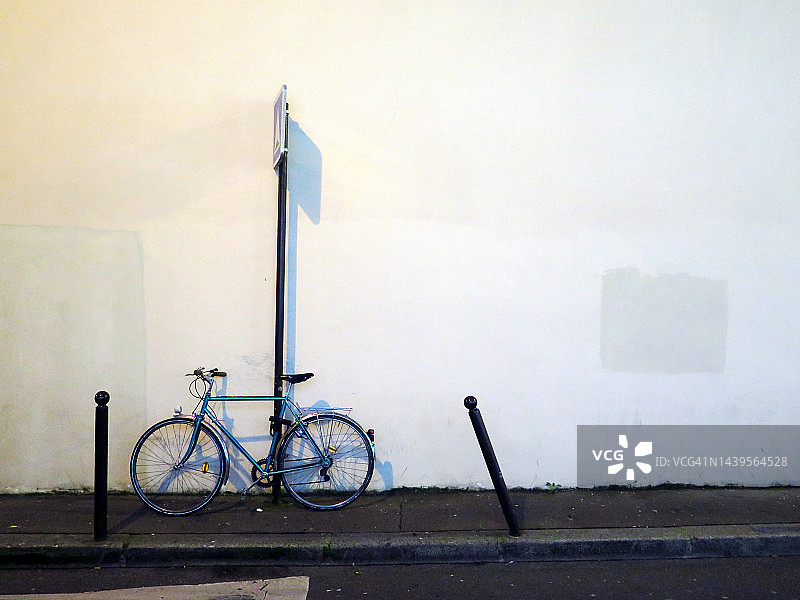 巴黎夜间街道上系在城市标志杆上的自行车图片素材