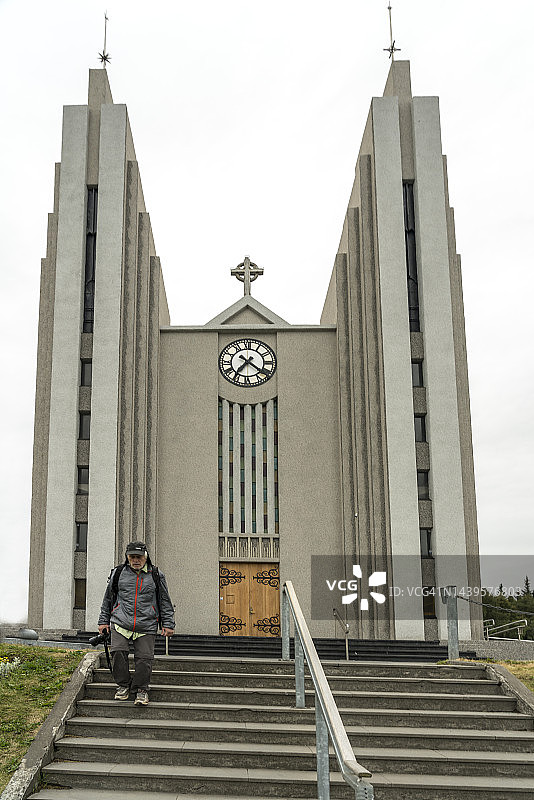 在冰岛阿克雷里地标教堂的楼梯上行走的一名男子图片素材