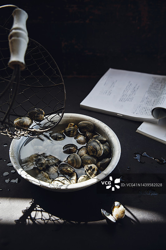 金属碗中水里的新鲜蛤蜊图片素材