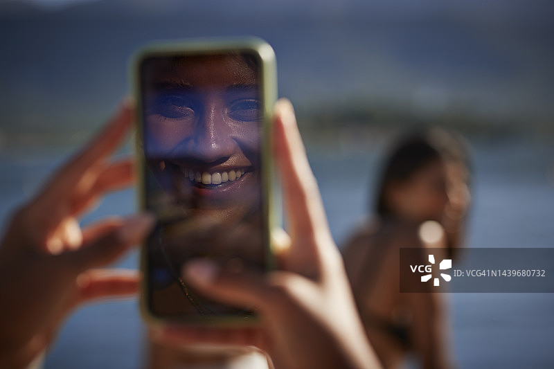 智能手机屏幕中的快乐女人倒影图片素材