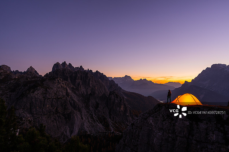 女子在暮色中带着帐篷进行山区探险图片素材