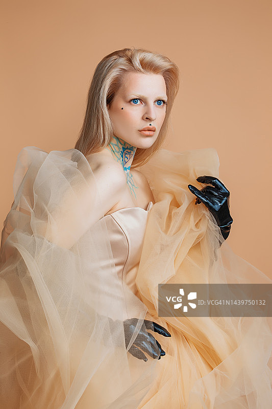 一位穿着奶油色连衣裙的漂亮金发女人图片素材
