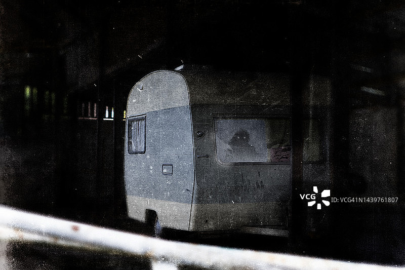 恐怖概念：幽灵废弃建筑物中被遗弃的房车图片素材