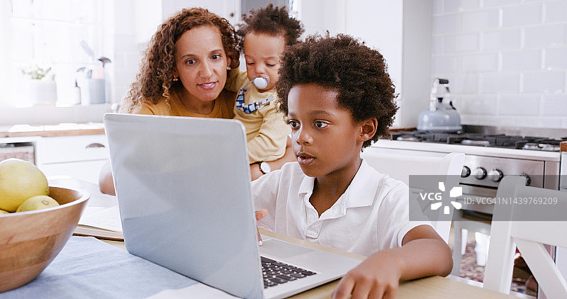 E-learning在线教育：母亲帮助孩子在笔记本电脑上进行虚拟学校学习，儿童网站课程APP订阅，在家上虚拟课图片素材