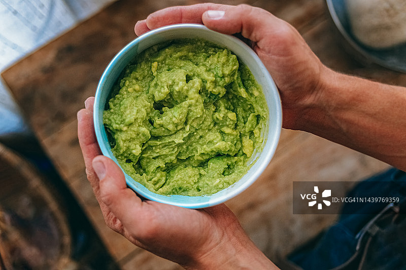 男人端着一碗鳄梨酱图片素材