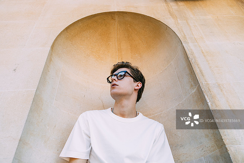 戴眼镜，向左看的年轻男子肖像图片素材