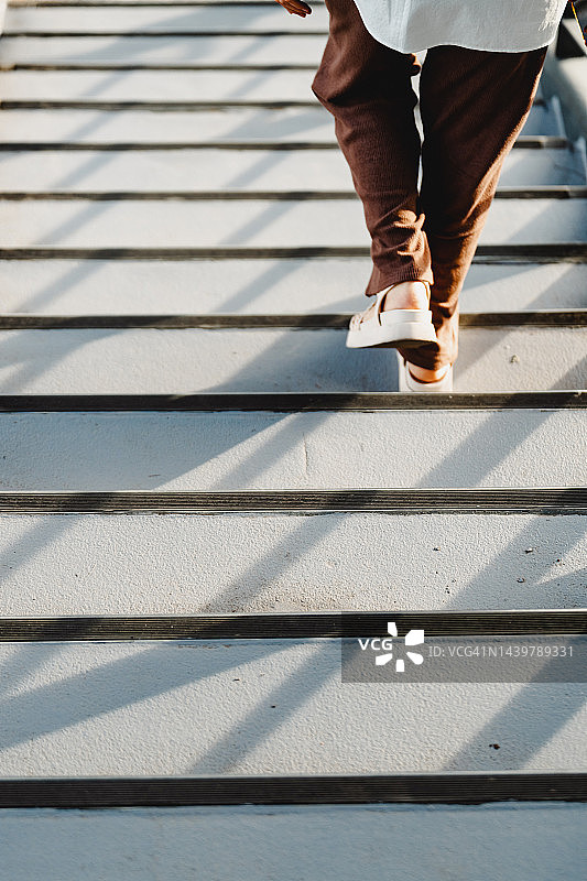 穿凉鞋的年轻亚洲女性在户外楼梯上图片素材