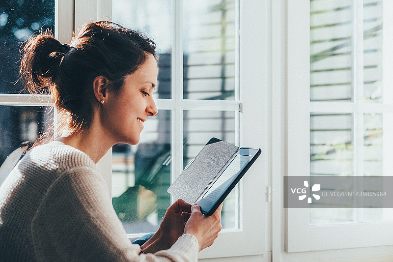 在家阅读电子书的女人图片素材