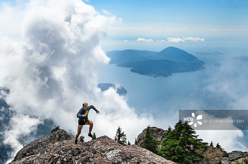 男子在沿海山脊奔跑图片素材
