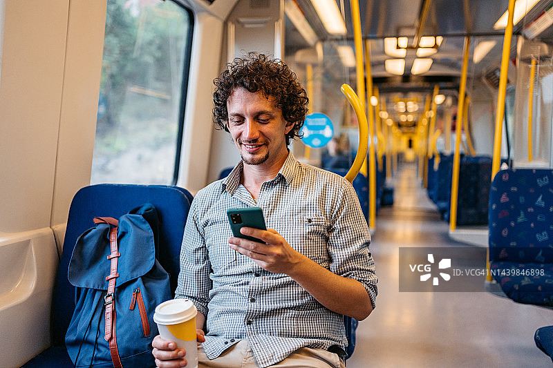 在斯德哥尔摩地铁上使用手机的年轻男人图片素材