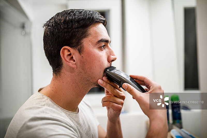 年轻男人进行晨间剃须图片素材