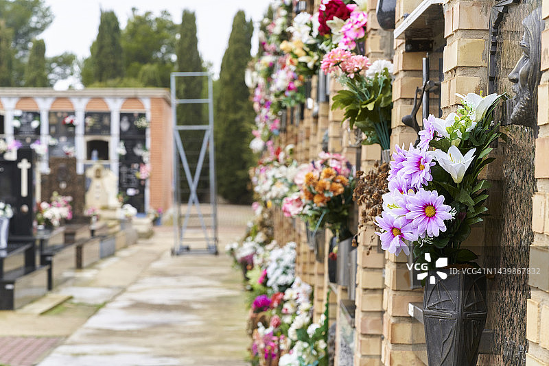 纪念公墓墙上的墓碑，附有鲜花，背景是楼梯图片素材
