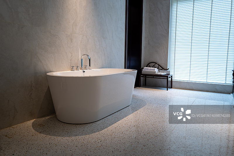 浴室窗边的陶瓷浴缸与水龙头图片素材