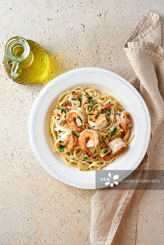 烤虾意面配奶油白汁，海鲜意面，顶部视角，留白，地中海美食，石桌，意大利美食图片素材
