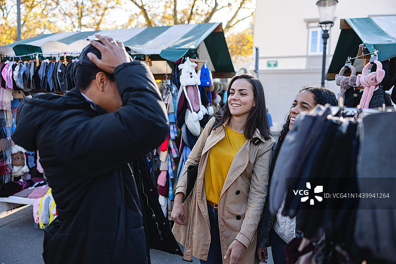 朋友们在街头市场摊位上购买服装图片素材