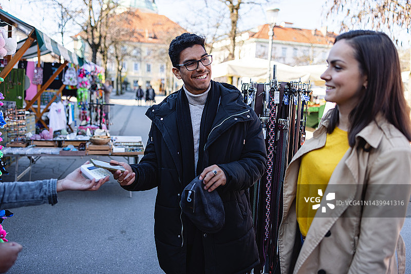 西班牙裔男人在街市用手机买衣服图片素材