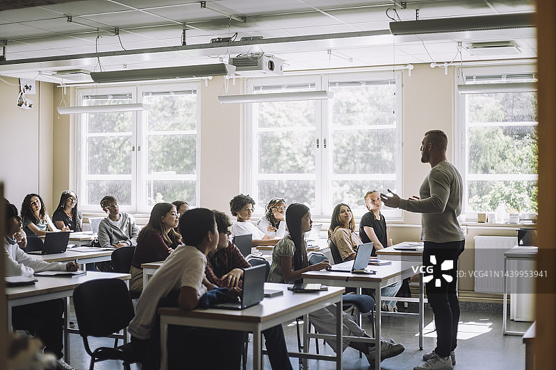 教授在初中课堂上为男女学生讲解图片素材