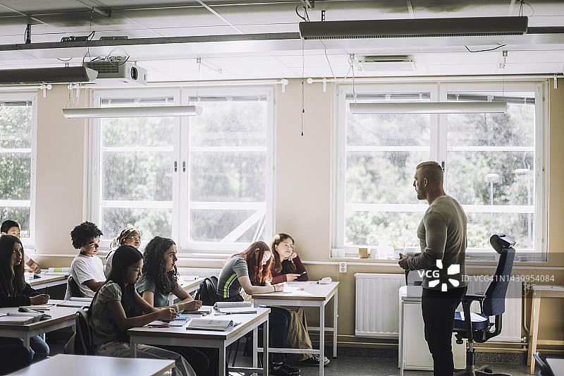 男教授在学校培训班给初中生讲解图片素材