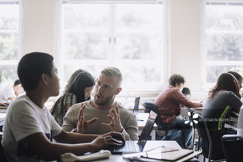 在初中培训班上为青少年学生讲解的男教授图片素材