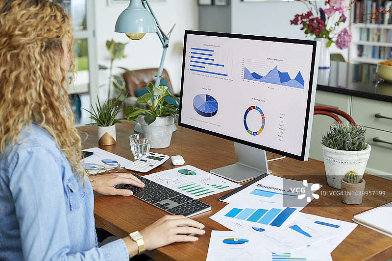 女商人正在桌面电脑上准备财务图表图片素材